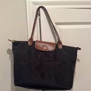 Longchamp bag, black bag and brown leather details.